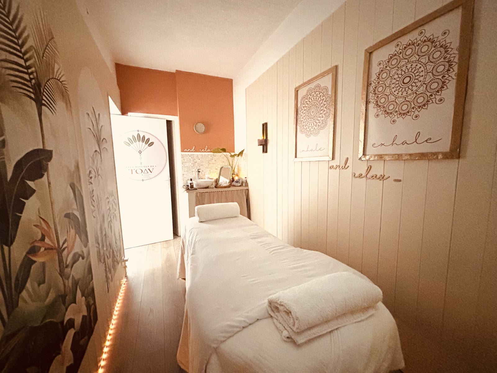 Cabine de soin des Rituels de Toav : table de massage, fresque végétale et ambiance cocooning